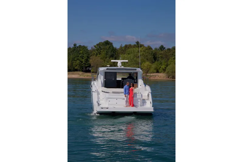  Yacht Photos Pics 2026 Cruisers Yachts 46 Cantius on serene water with passengers enjoying the view.