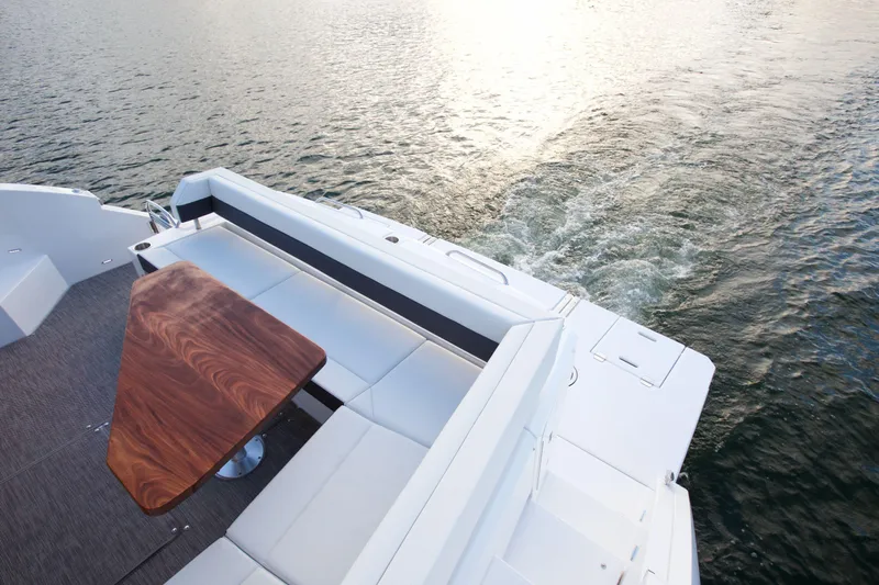  Yacht Photos Pics 2026 Cruisers Yachts 46 Cantius deck with elegant seating and wooden table on water.