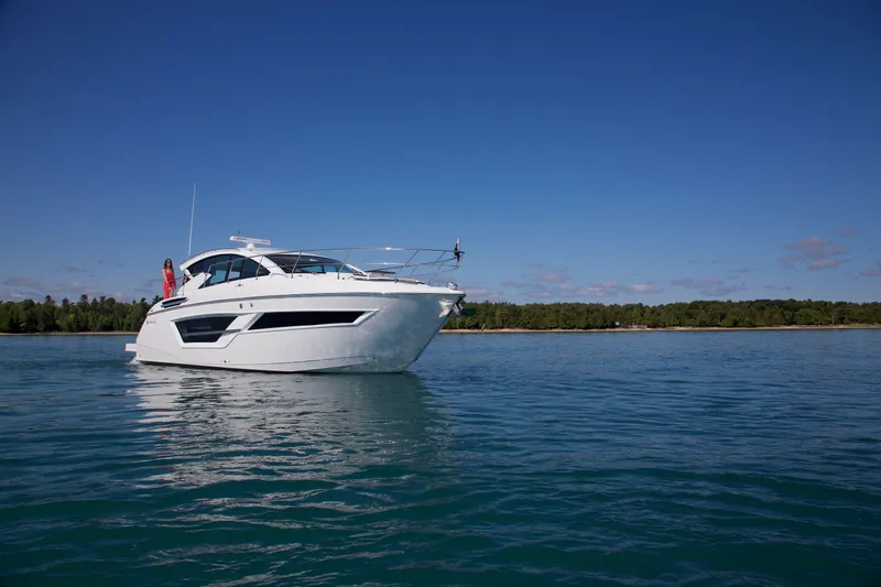  Yacht Photos Pics 2026 Cruisers Yachts 46 Cantius on serene water with clear blue sky.