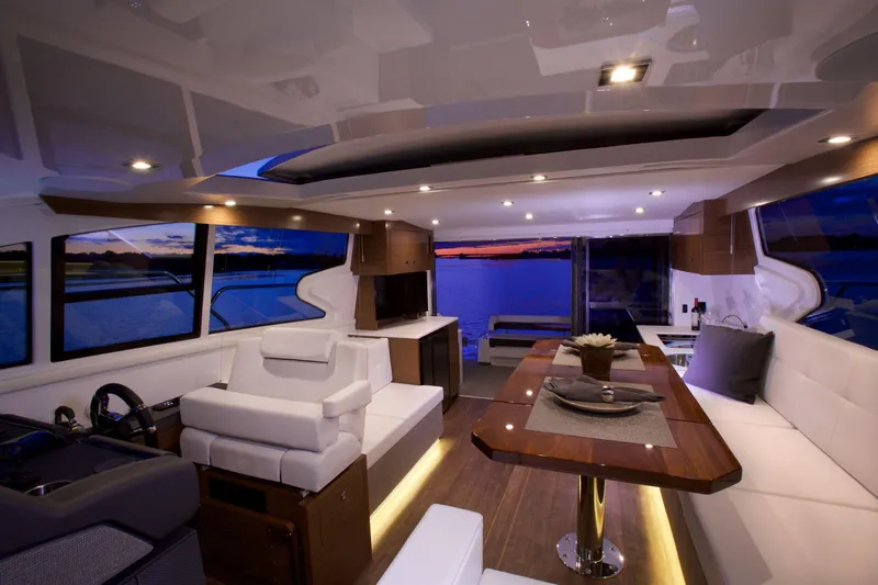  Yacht Photos Pics Luxurious interior of 2026 Cruisers Yachts 46 Cantius at sunset, featuring elegant seating and dining area.