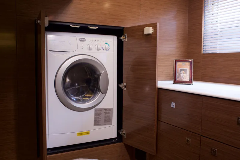  Yacht Photos Pics Laundry area with washer in 2026 Cruisers Yachts 46 Cantius, featuring wood cabinetry.