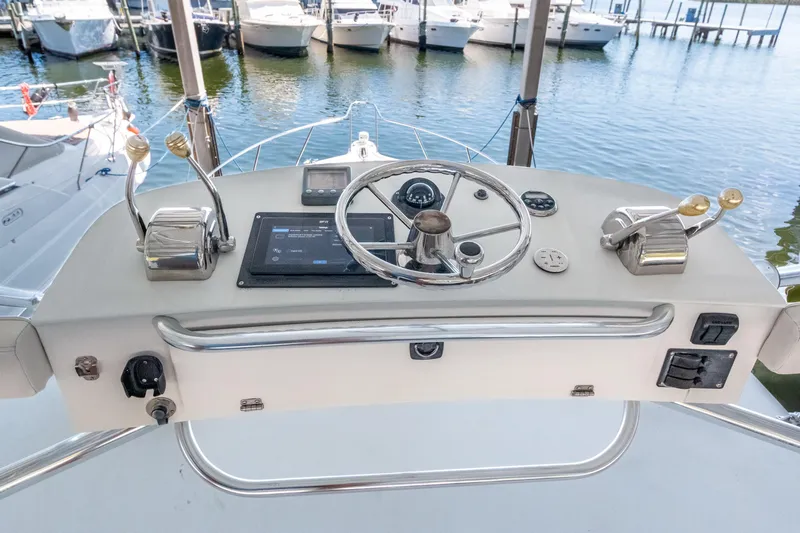 Her Majesty Yacht Photos Pics Helm of 2007 Tiara Yachts 3800 Open with steering wheel and controls, docked at marina.
