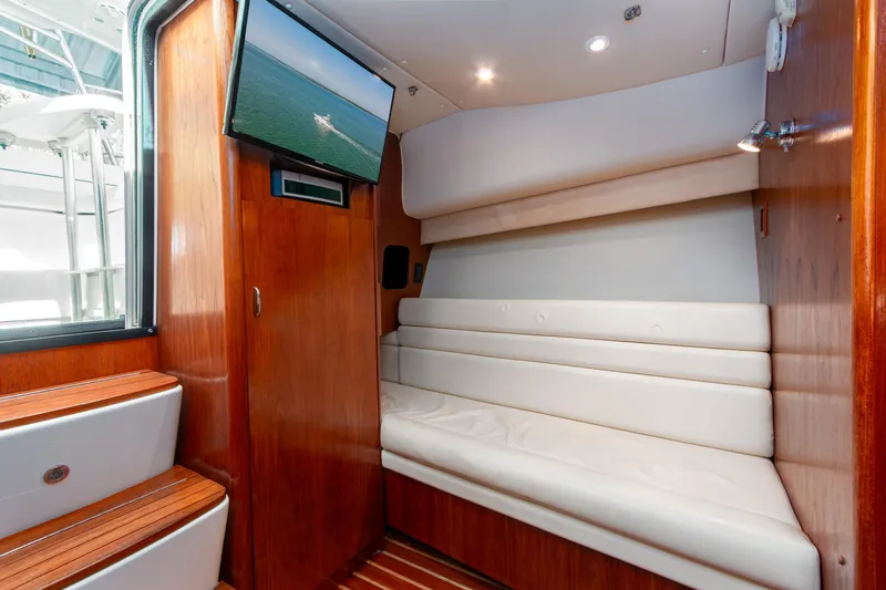 Her Majesty Yacht Photos Pics Interior of 2007 Tiara Yachts 3800 Open with white seating and mounted TV.