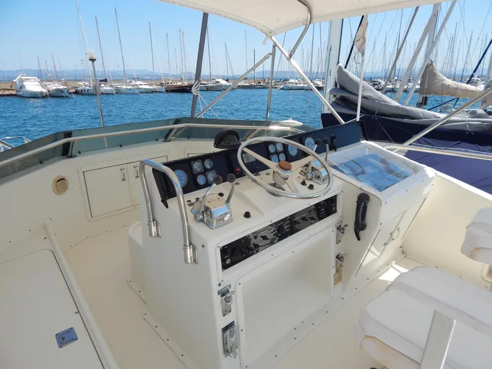  Yacht Photos Pics 1989 Hatteras 45 Convertible yacht helm with steering wheel and controls, docked in marina.