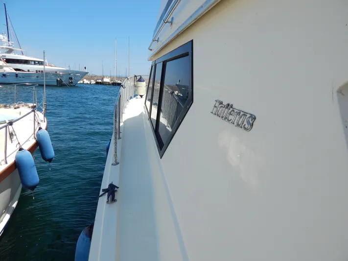  Yacht Photos Pics 1989 Hatteras 45 Convertible yacht docked in a marina, side view.