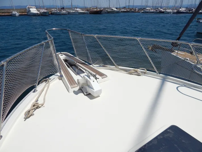  Yacht Photos Pics Bow of 1989 Hatteras 45 Convertible yacht with railing and anchor, docked in marina.