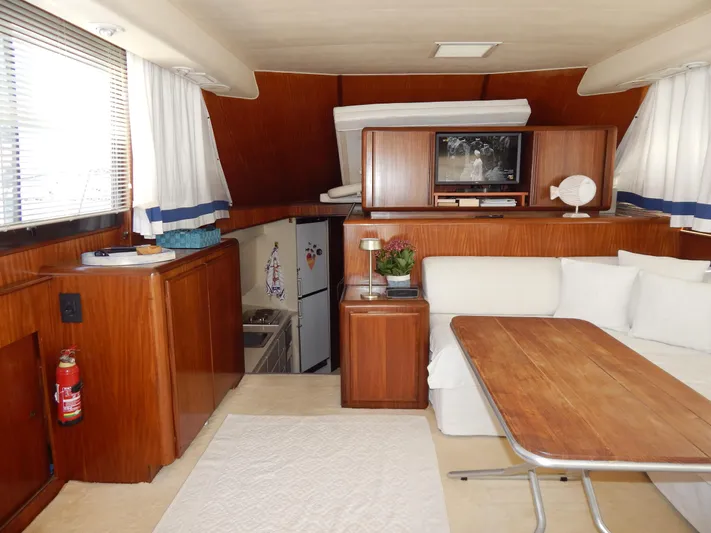  Yacht Photos Pics 1989 Hatteras 45 Convertible yacht interior with wood paneling, dining area, and compact kitchen.