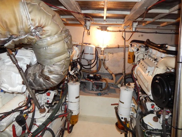  Yacht Photos Pics Engine room of 1989 Hatteras 45 Convertible yacht, showcasing dual engines and mechanical components.