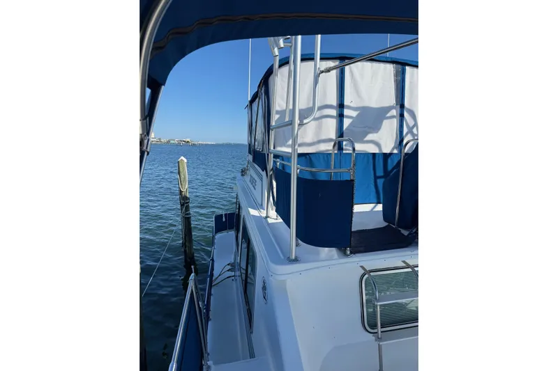 Ski Breeze Yacht Photos Pics 1996 Harbor Master 52 Wide Body boat docked on calm water under clear blue sky.