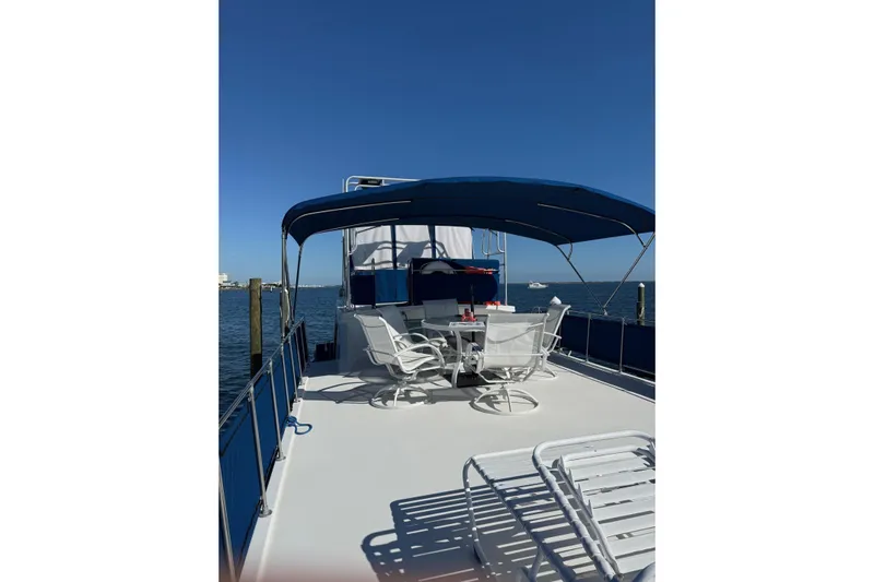 Ski Breeze Yacht Photos Pics 1996 Harbor Master 52 Wide Body yacht deck with seating under blue canopy.