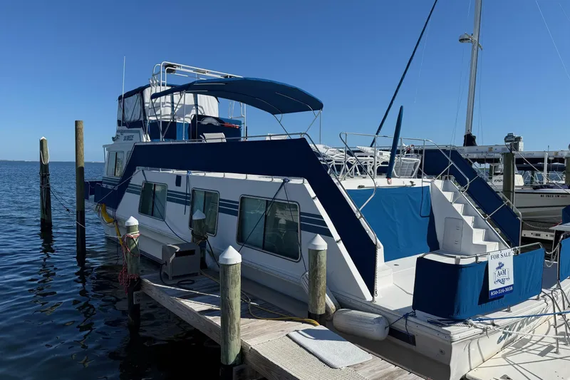 Ski Breeze Yacht Photos Pics 1996 Harbor Master 52 Wide Body houseboat docked, featuring blue and white exterior, for sale.