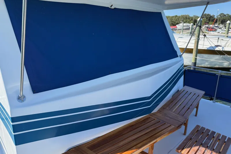 Ski Breeze Yacht Photos Pics 1996 Harbor Master 52 Wide Body boat with blue awning and wooden seating on deck.