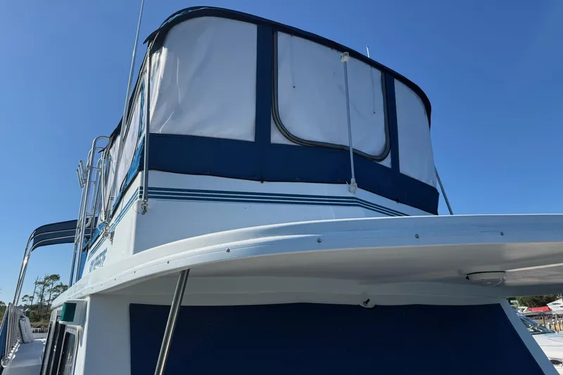 Ski Breeze Yacht Photos Pics 1996 Harbor Master 52 Wide Body boat with blue and white canopy under clear sky.