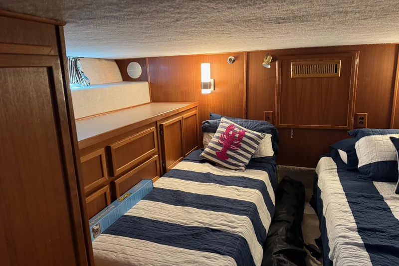 Ski Breeze Yacht Photos Pics Cozy cabin interior of 1996 Harbor Master 52 Wide Body with twin beds and nautical decor.