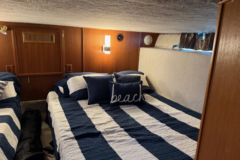 Ski Breeze Yacht Photos Pics Cozy bedroom in 1996 Harbor Master 52 Wide Body yacht with striped bedding and nautical decor.