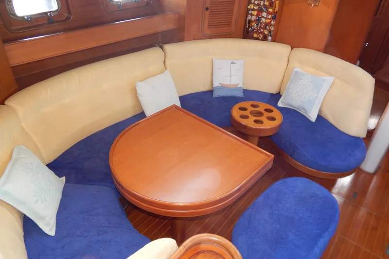  Yacht Photos Pics Cozy interior of 1992 Tayana 55 yacht with curved seating and wooden table.