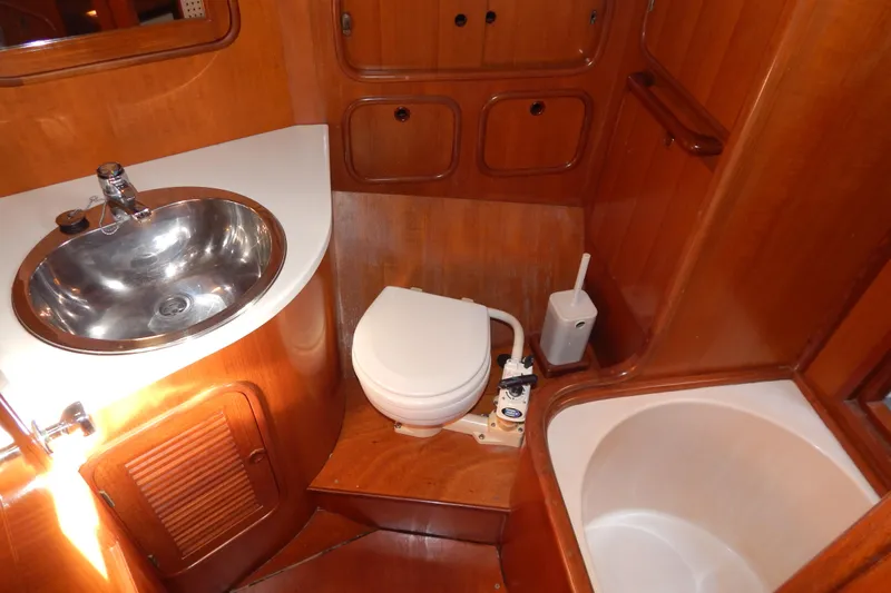  Yacht Photos Pics Bathroom interior of 1992 Tayana 55 yacht with sink, toilet, and wooden cabinetry.