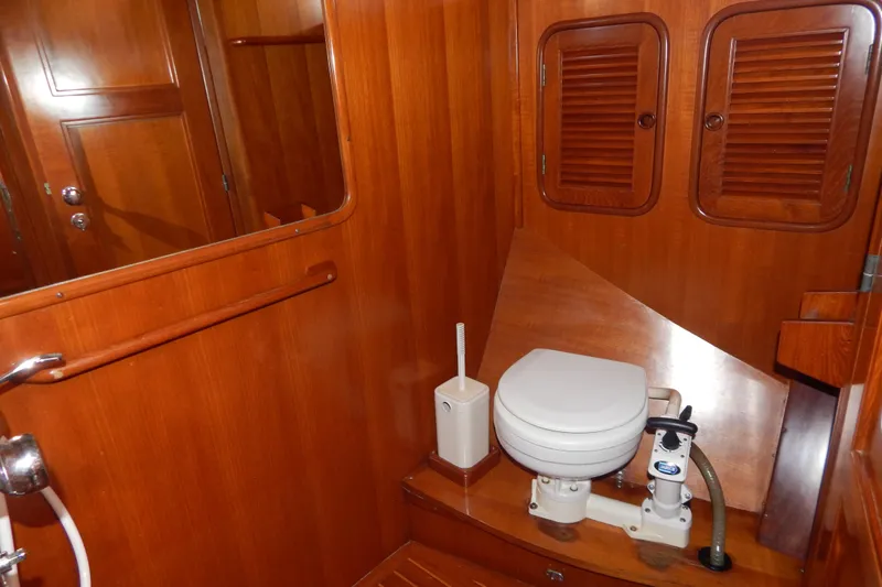  Yacht Photos Pics Wood-paneled bathroom in 1992 Tayana 55 yacht with marine toilet and storage cabinets.