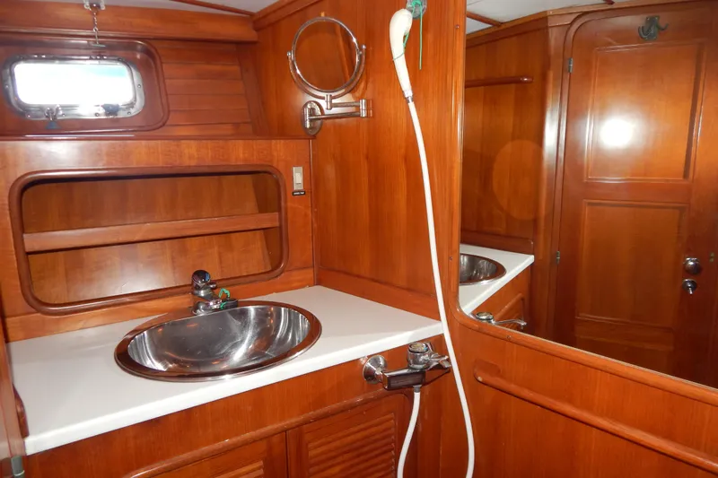  Yacht Photos Pics Wooden bathroom interior of 1992 Tayana 55 yacht with sink and mirror.