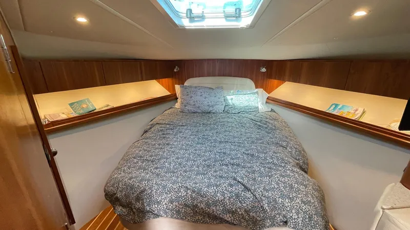  Yacht Photos Pics Luxurious cabin interior of 2007 Tiara Yachts 3800 Open with cozy bedding and wooden accents.