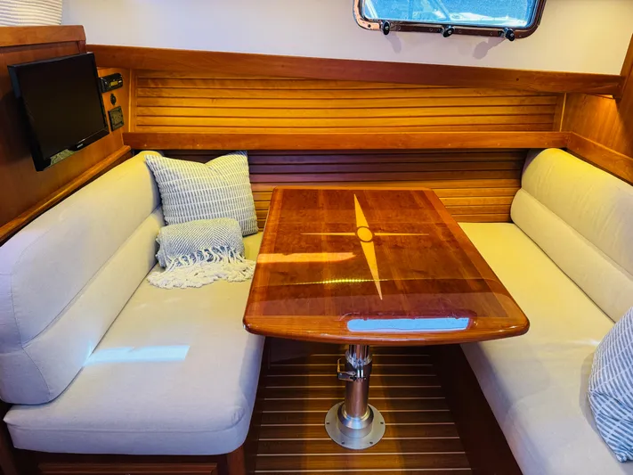 On Holidays - Reserved Yacht Photos Pics Interior of 2018 Sabre 42 Salon Express with wooden table and cushioned seating.