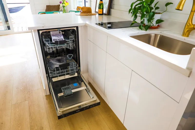  Yacht Photos Pics Modern kitchen on Hank's 40 Houseboat 2025 with open dishwasher and sleek white cabinetry.