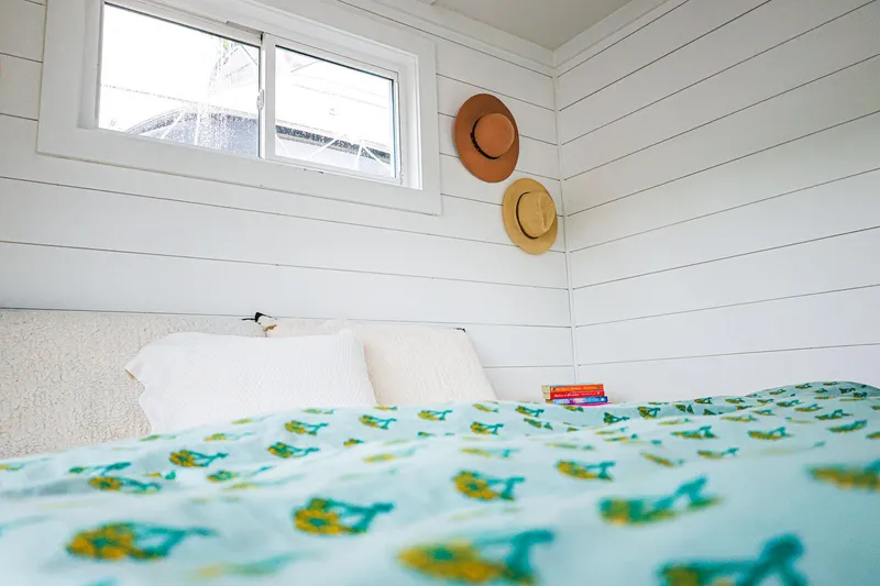  Yacht Photos Pics Cozy bedroom in Hank's 40 Houseboat, featuring white shiplap walls and decorative hats.