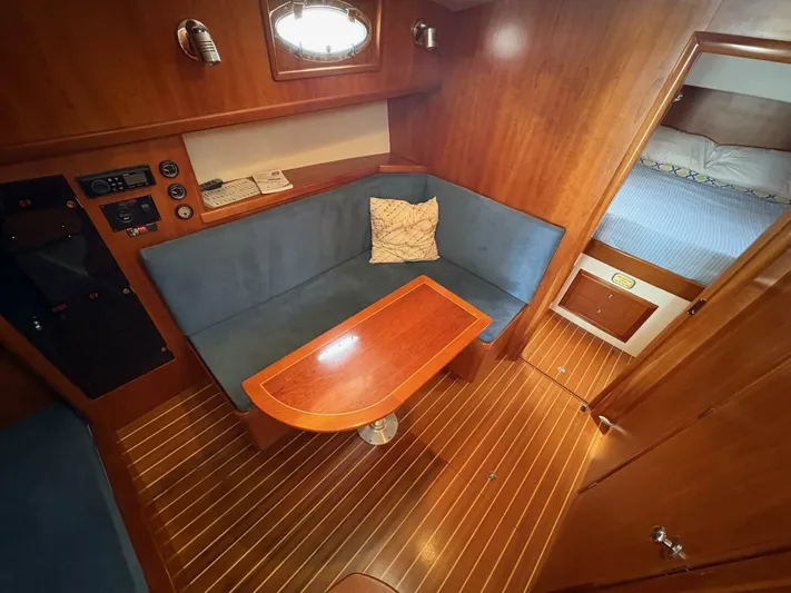 N'baluba Yacht Photos Pics 2008 Rivolta Coupe 4.5 interior with wooden finish, blue seating, and cozy cabin space.
