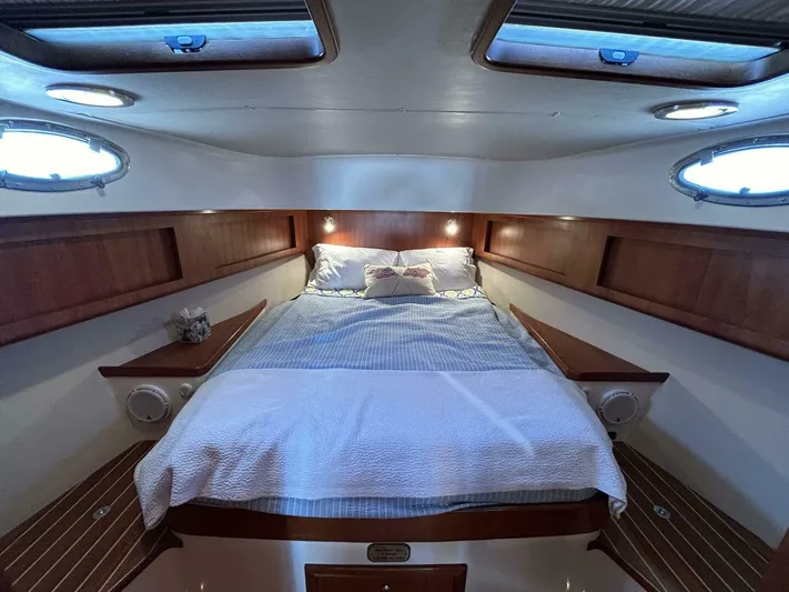 N'baluba Yacht Photos Pics Luxurious 2008 Rivolta Coupe 4.5 cabin interior with cozy bed and wooden accents.
