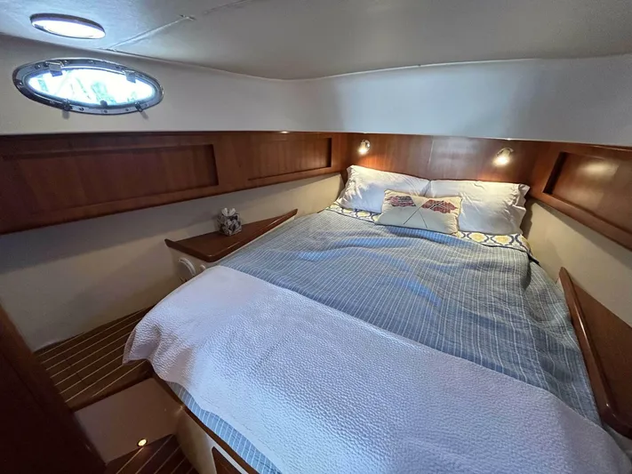 N'baluba Yacht Photos Pics Cozy bedroom interior of 2008 Rivolta Coupe 4.5 with wood accents and soft lighting.
