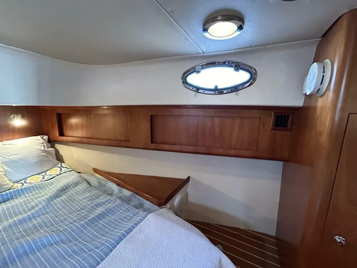 N'baluba Yacht Photos Pics Cozy cabin interior of 2008 Rivolta Coupe 4.5 with wooden accents and porthole window.