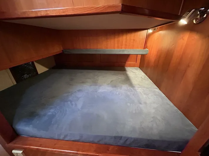 N'baluba Yacht Photos Pics Cozy wooden interior cabin bed in 2008 Rivolta Coupe 4.5, featuring soft blue bedding.