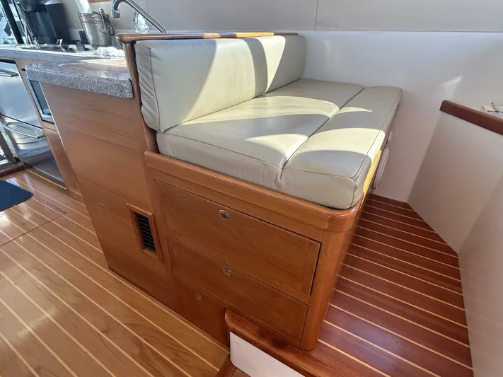 N'baluba Yacht Photos Pics 2008 Rivolta Coupe 4.5 interior with cushioned seating and wooden flooring.