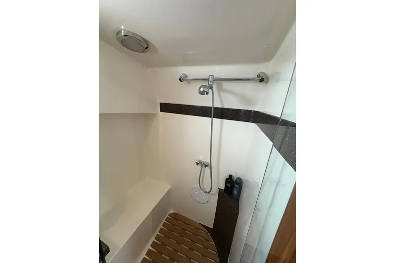 N'baluba Yacht Photos Pics Compact shower area in a 2008 Rivolta Coupe 4.5, featuring modern fixtures and wooden floor mat.