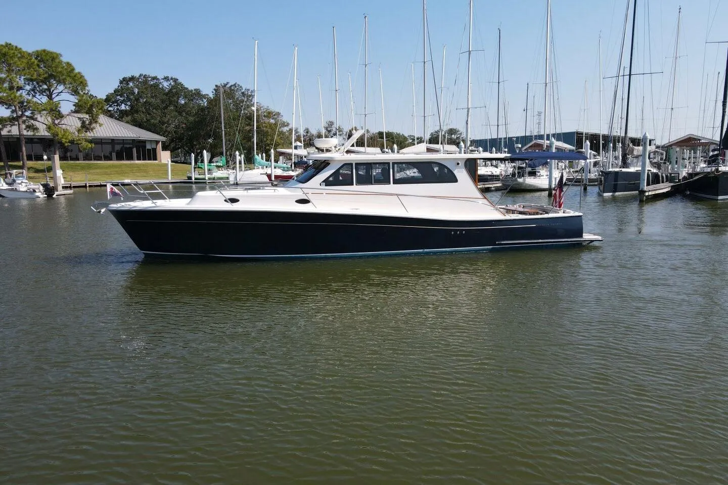2008 Rivolta Coupe 4.5 yacht docked in a marina, surrounded by sailboats.