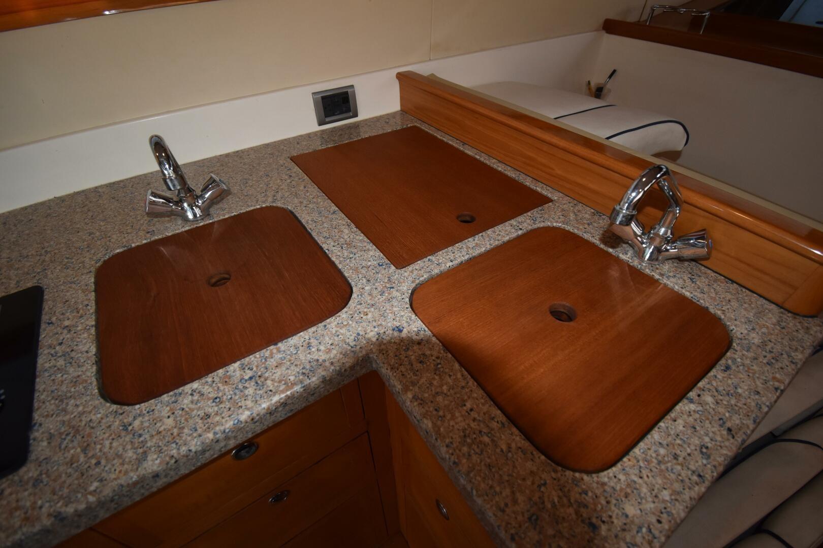 Luxury yacht kitchen with dual sinks, wooden covers, and granite countertop in a 2008 Rivolta Coupe 4.5.