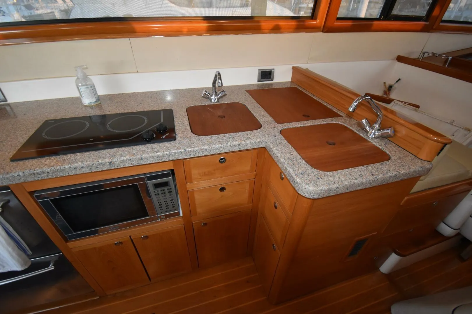 2008 Rivolta Coupe 4.5 kitchen with granite countertops, stove, microwave, and wooden cabinetry.