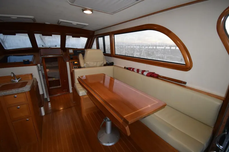 N'baluba Yacht Photos Pics Luxurious interior of 2008 Rivolta Coupe 4.5 yacht with wooden furnishings and seating area.