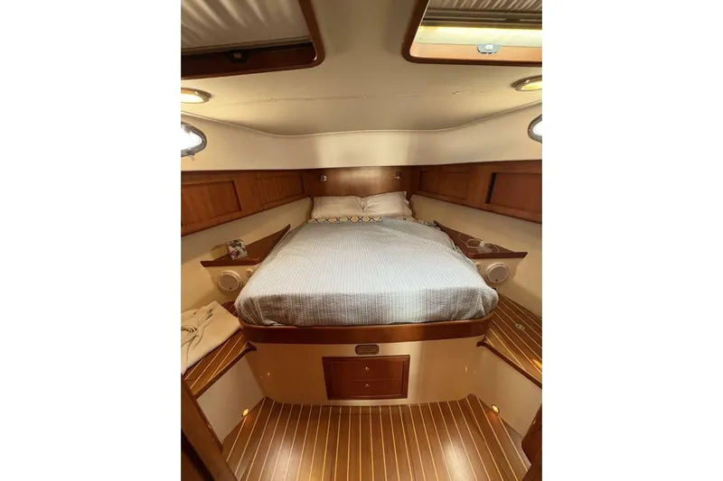 N'baluba Yacht Photos Pics Luxurious cabin interior of 2008 Rivolta Coupe 4.5 with wooden accents and cozy bedding.