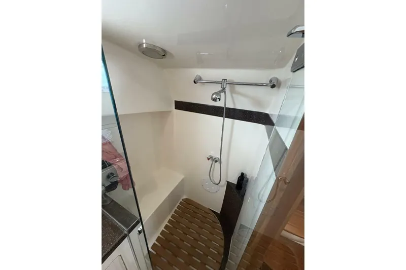 N'baluba Yacht Photos Pics Compact shower area in 2008 Rivolta Coupe 4.5 with modern fixtures and wooden floor mat.