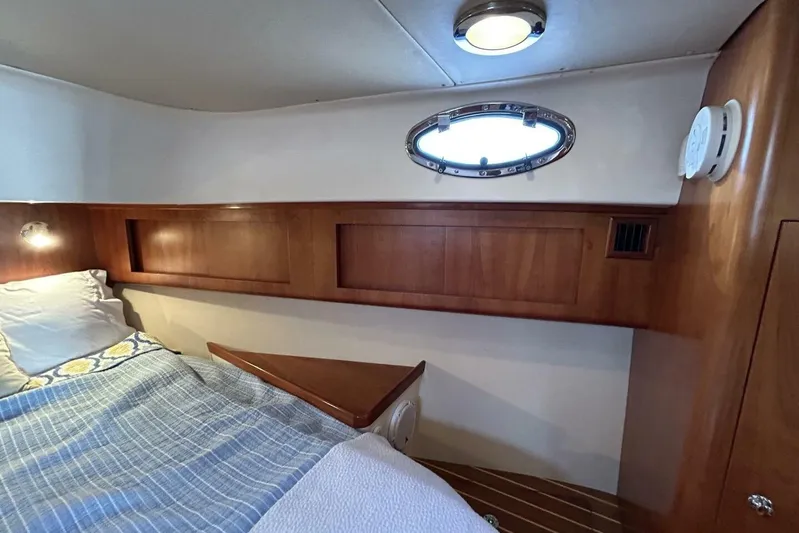 N'baluba Yacht Photos Pics Cozy cabin interior of 2008 Rivolta Coupe 4.5 with wooden accents and porthole window.