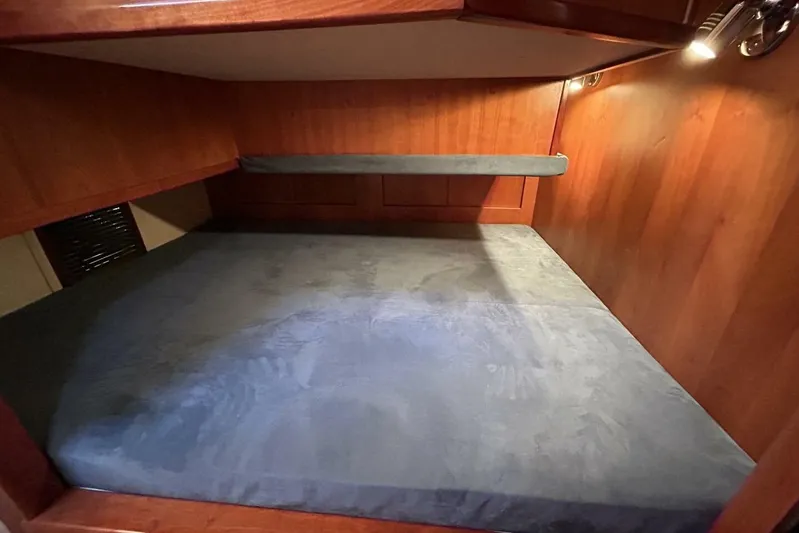 N'baluba Yacht Photos Pics Cozy wooden interior of 2008 Rivolta Coupe 4.5 with blue cushioned bed.