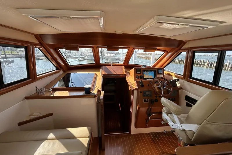 N'baluba Yacht Photos Pics Luxurious 2008 Rivolta Coupe 4.5 yacht interior with wooden accents and navigation equipment.