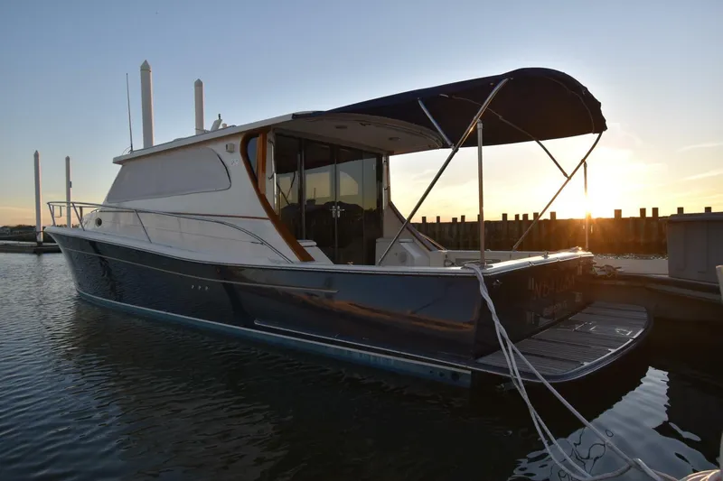 N'baluba Yacht Photos Pics 2008 Rivolta Coupe 4.5 yacht docked at sunset, featuring sleek design and canopy.