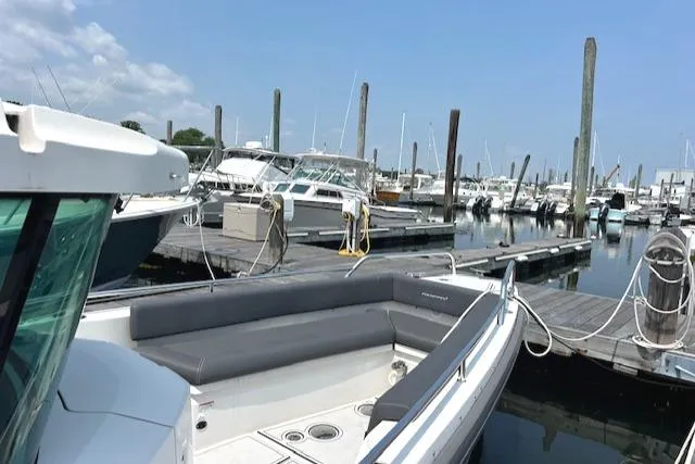  Yacht Photos Pics 2019 Axopar 28 boat docked at a marina with other vessels.