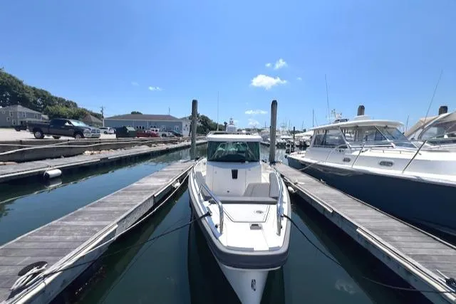  Yacht Photos Pics 2019 Axopar 28 boat docked at a marina under a clear blue sky.