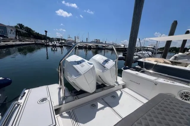 Yacht Photos Pics 2019 Axopar 28 boat with dual engines docked at a marina under a clear blue sky.