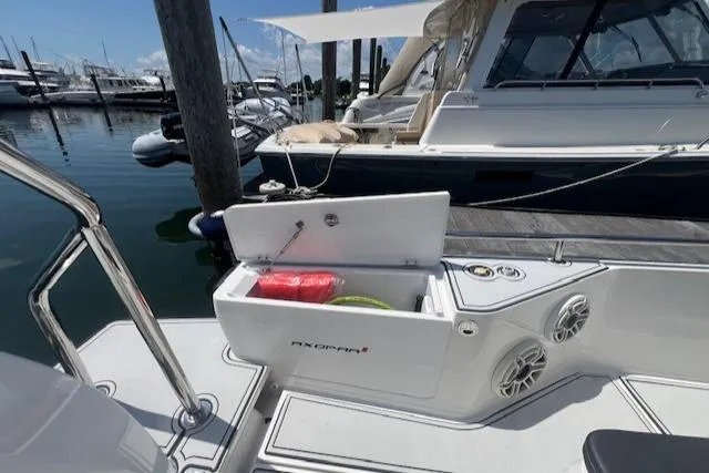  Yacht Photos Pics 2019 Axopar 28 boat with open storage compartment, docked at marina.