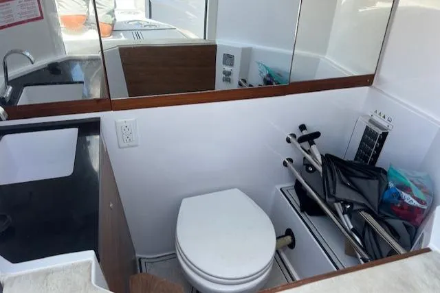  Yacht Photos Pics 2019 Axopar 28 boat bathroom with sink, toilet, and storage area.