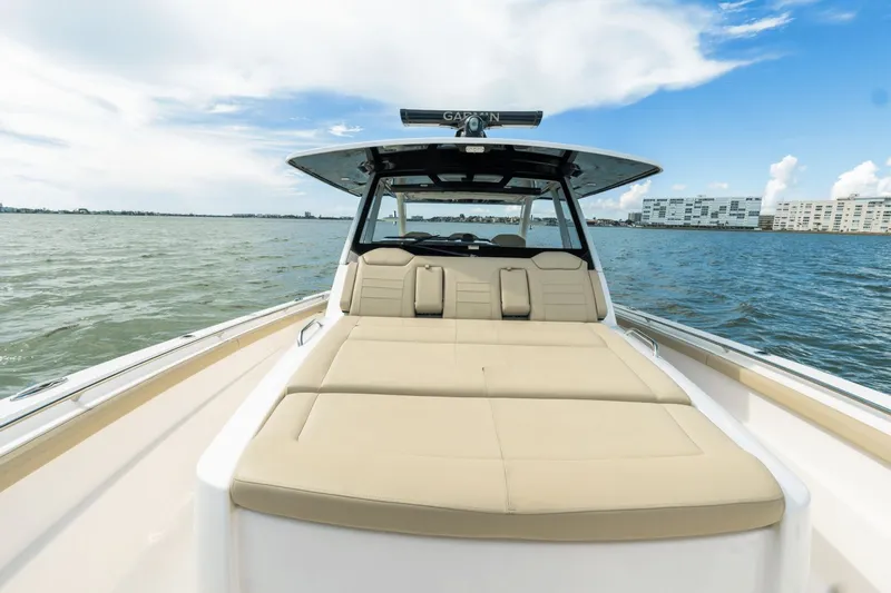 Pirates Bight Yacht Photos Pics 2019 Pursuit 408 boat with spacious deck, cruising on calm waters under a clear sky.